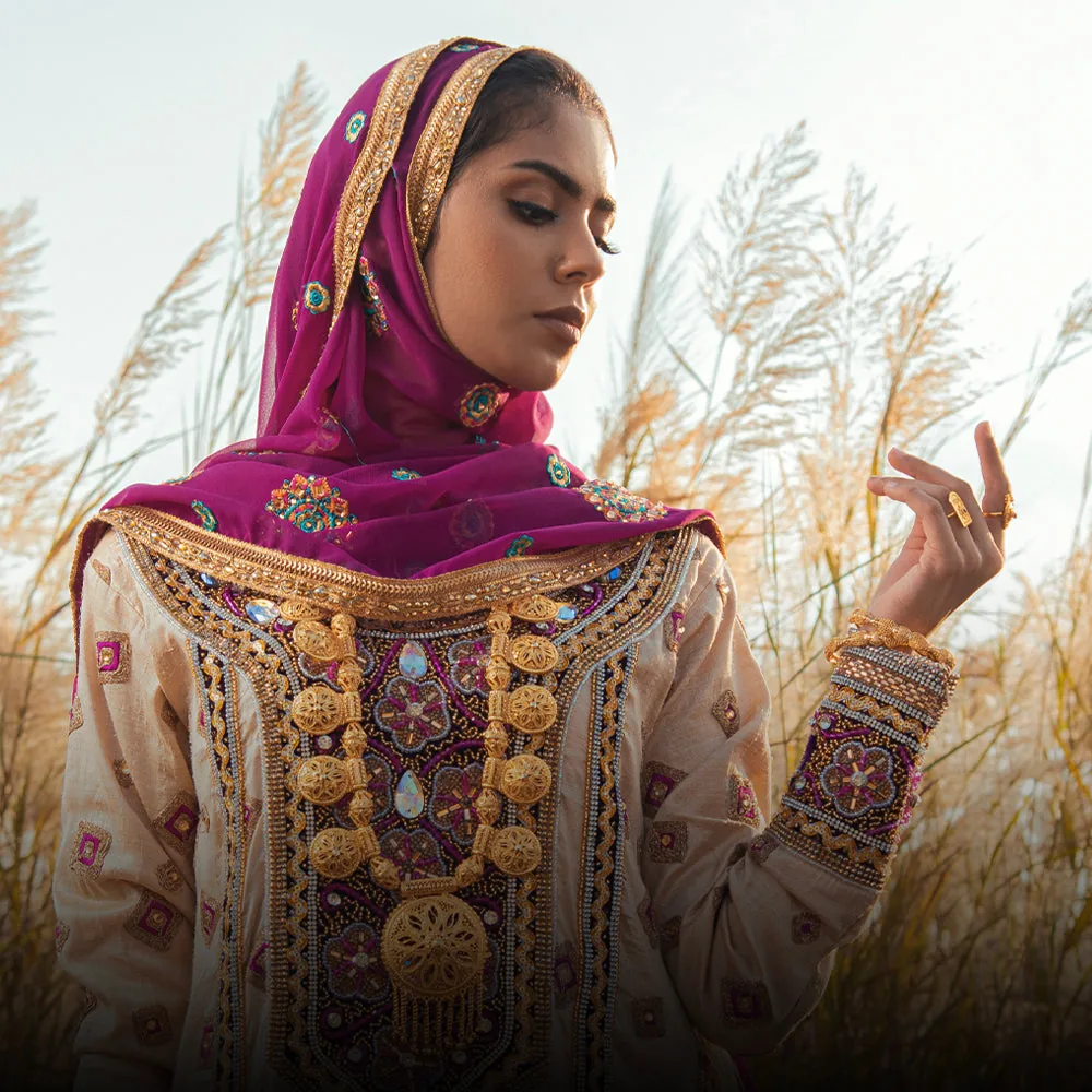A woman in Omani dress among khareef grass